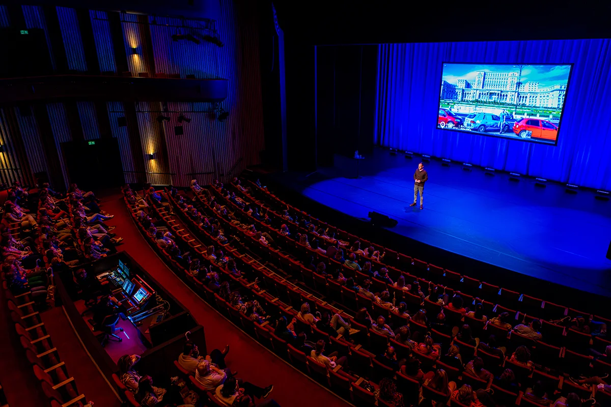 Wiebe Wakker geeft een presentatie in een theater voor een groot publiek.