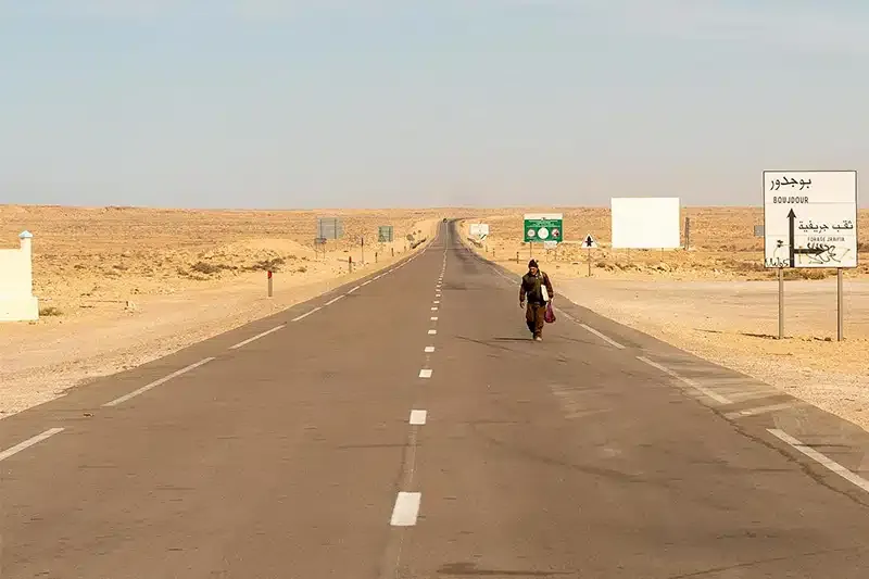 Man-walking-on-highway-in-Western-Sahara