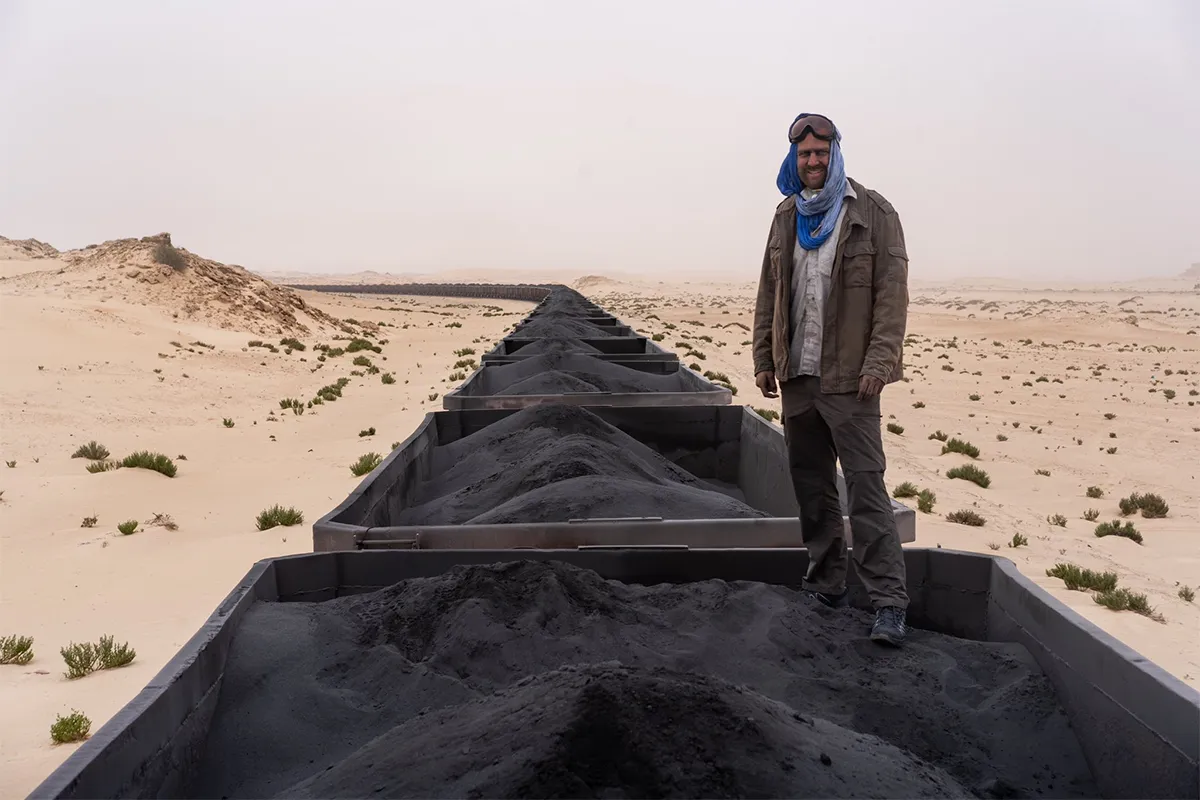 Wiebe Wakker on a carriage of the Mauritanian Iron Ore Train Wiebe Wakker standing on a carriage of the Mauritanian Iron Ore Train, riding through the Sahara desert.