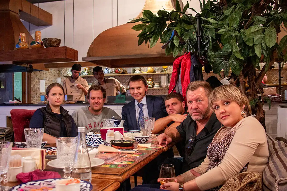 Wiebe Wakker aan een eettafel in een restaurant met zijn gastheren in Sint-Petersburg, Rusland.